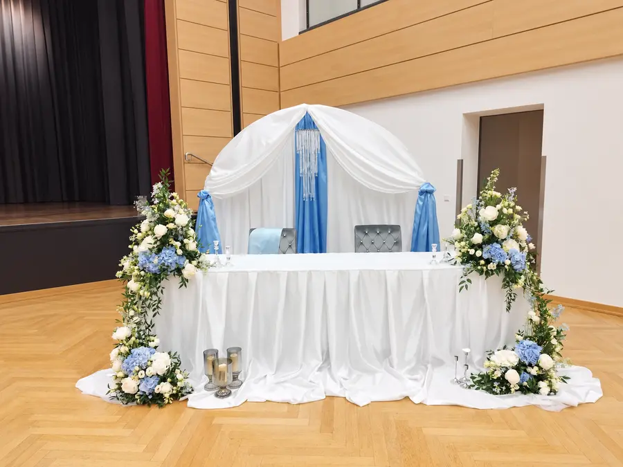 Festliche Hochzeitsdekoration mit weißen und hellblauen Blüten