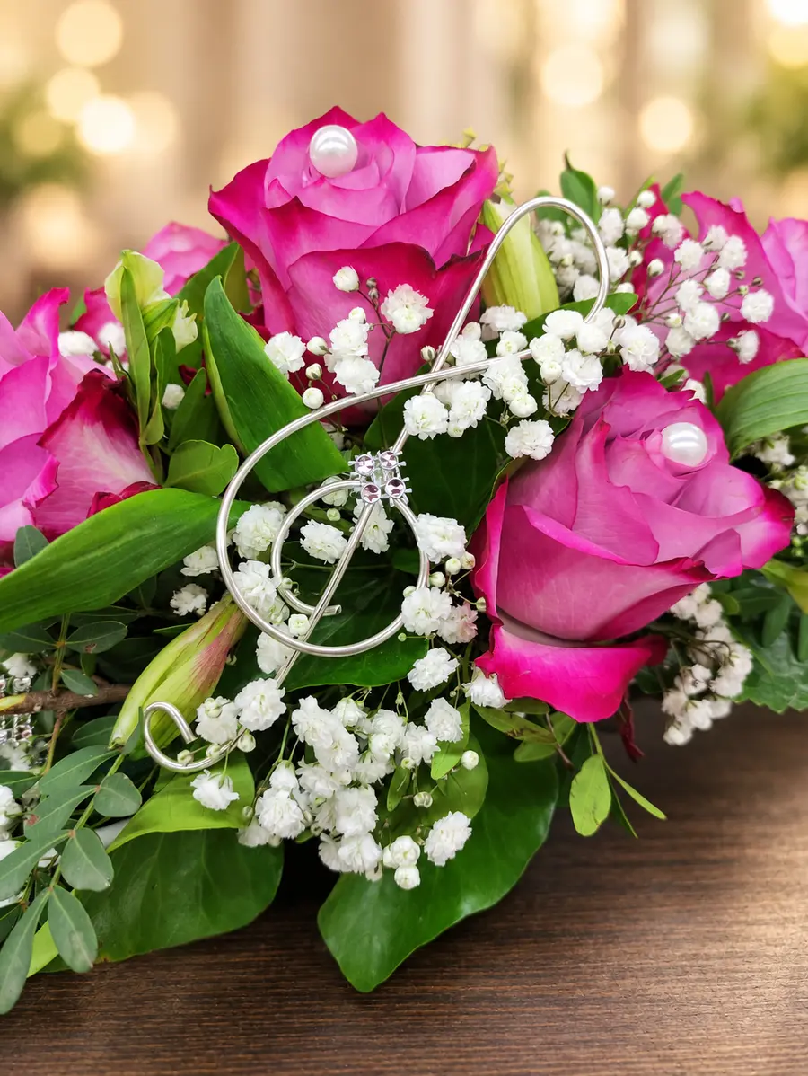 Pinkfarbener Rosenstrauß mit Schleifenornament