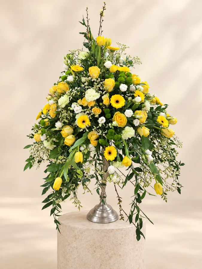 Großes Trauergesteck mit gelben Rosen, Gerbera und Tulpen sowie weißen Blüten