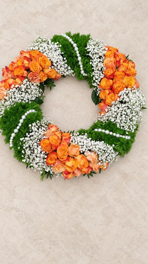 Trauerkranz mit orangefarbenen Rosen, Schleierkraut, Moos und Perlen